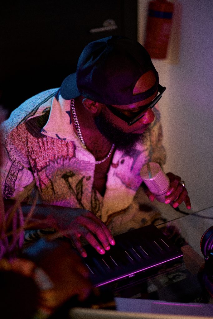 Samuel G holding a microphone and playing a keyboard